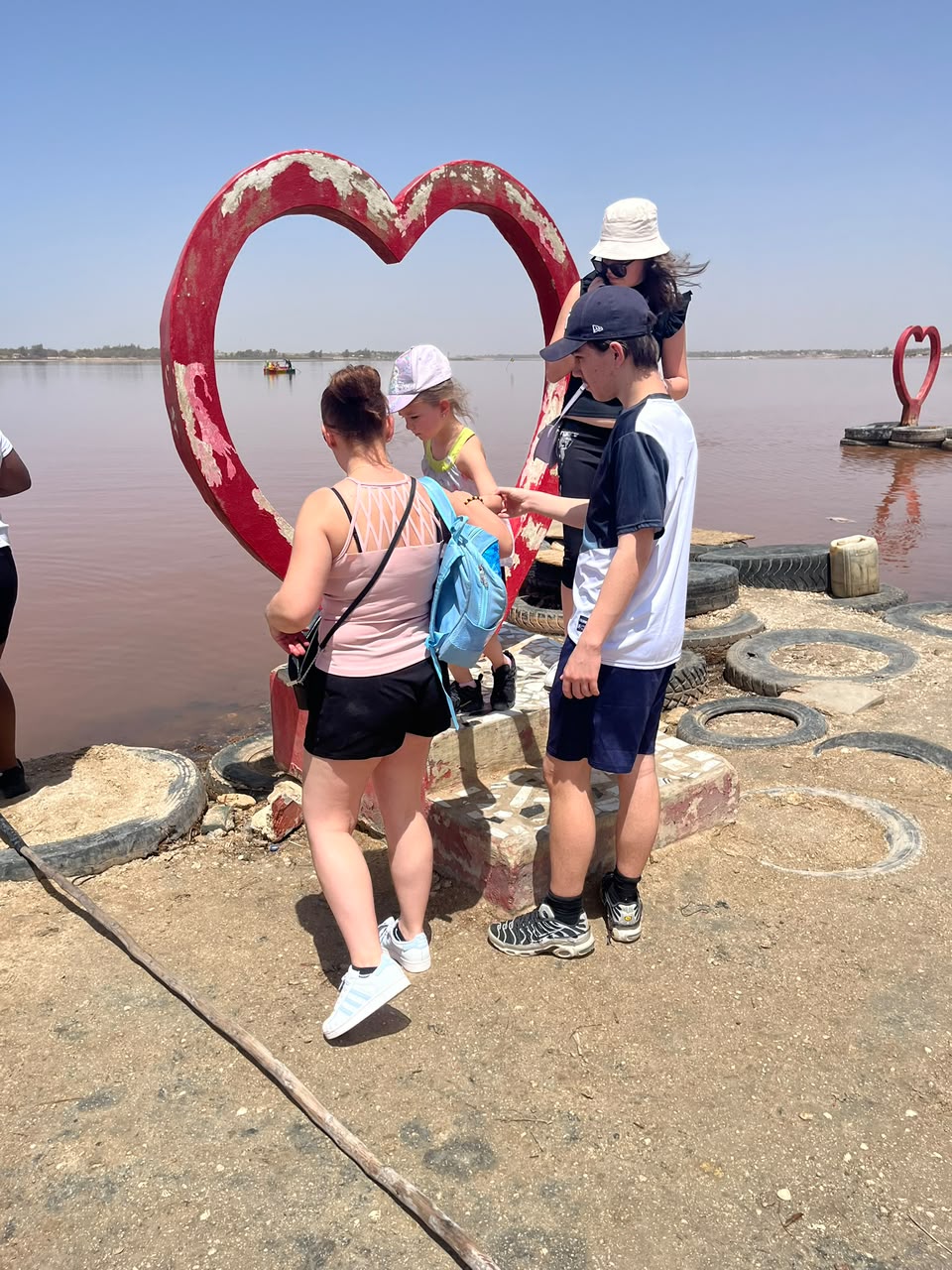 Groupe de visiteurs devant la sculpture en cœur au bord du Lac Rose au Sénégal