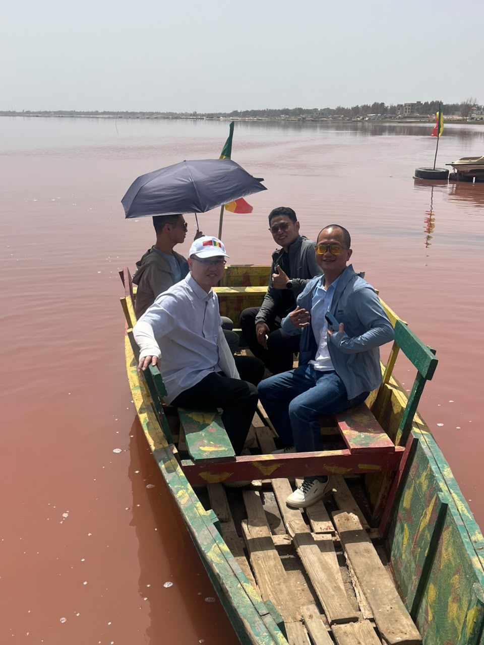 Visiteurs à bord d’une pirogue traditionnelle sur les eaux du Lac Rose
