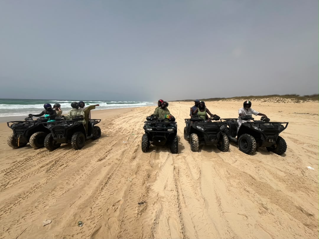 Participants en quad dans les dunes au bord de l’océan près du Lac Rose