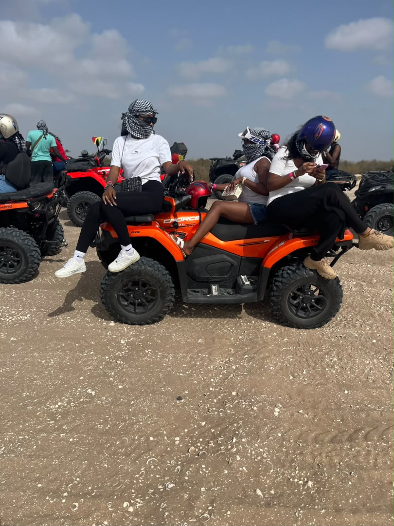 Amies posant sur un quad orange pendant une balade près du Lac Rose