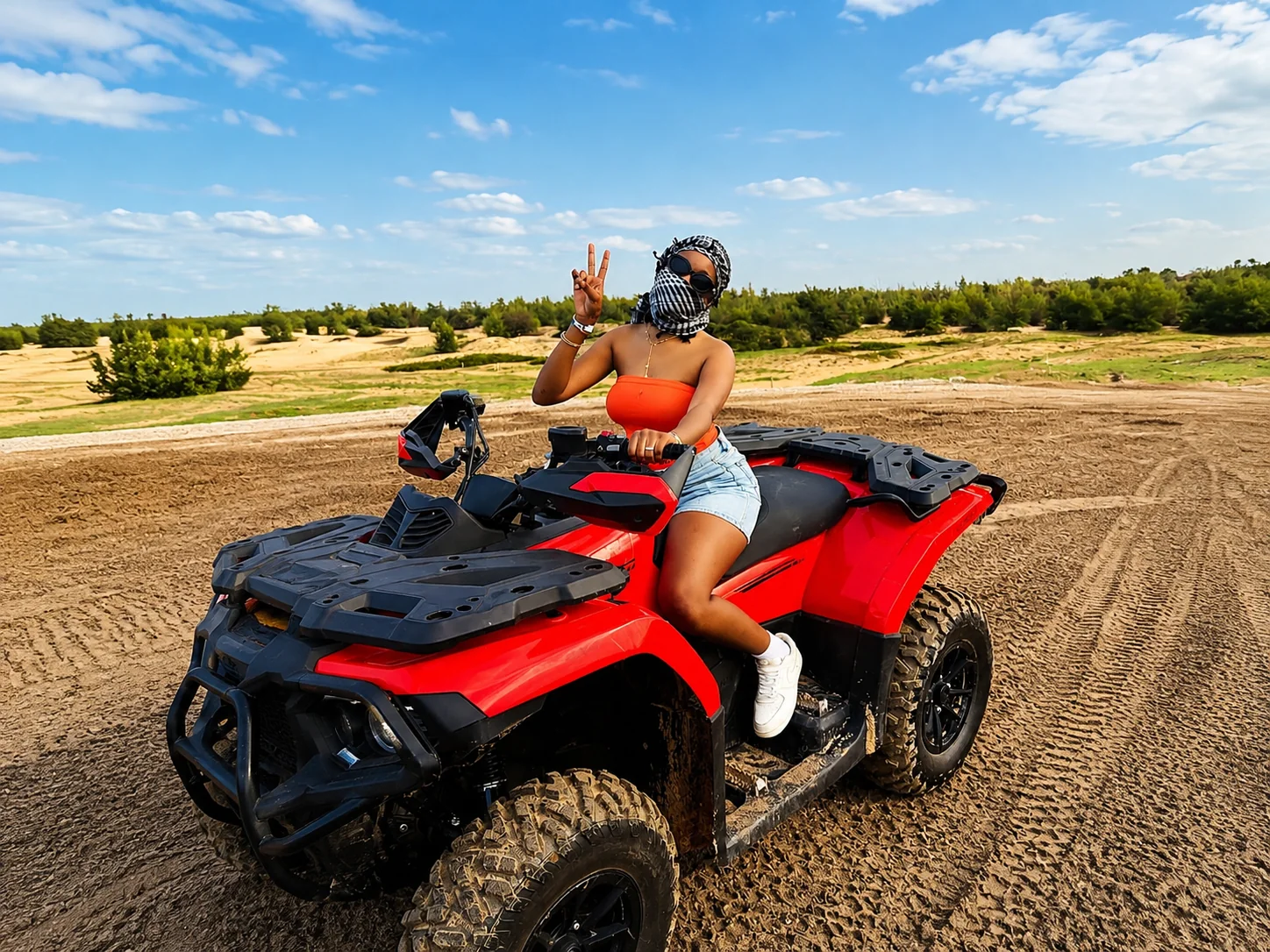 Balade en quad rouge sur une piste de sable du Lac Rose