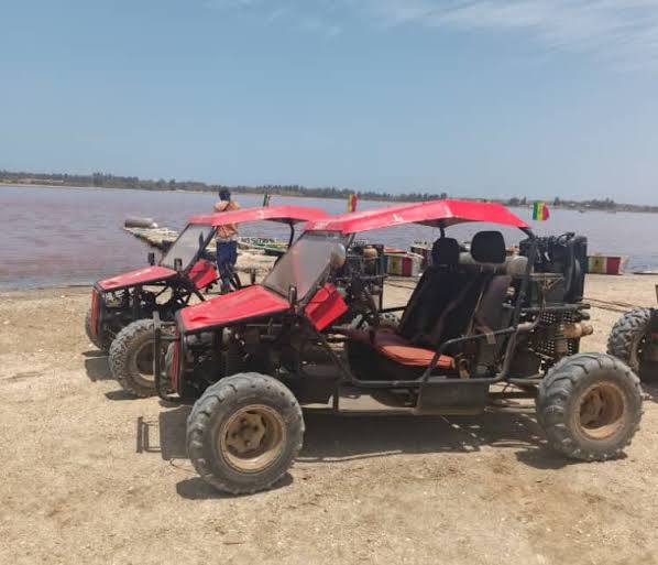 Deux buggys rouges stationnés au bord du Lac Rose au Sénégal