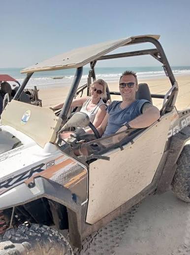 Couple installé dans un buggy tout-terrain sur la plage près du Lac Rose