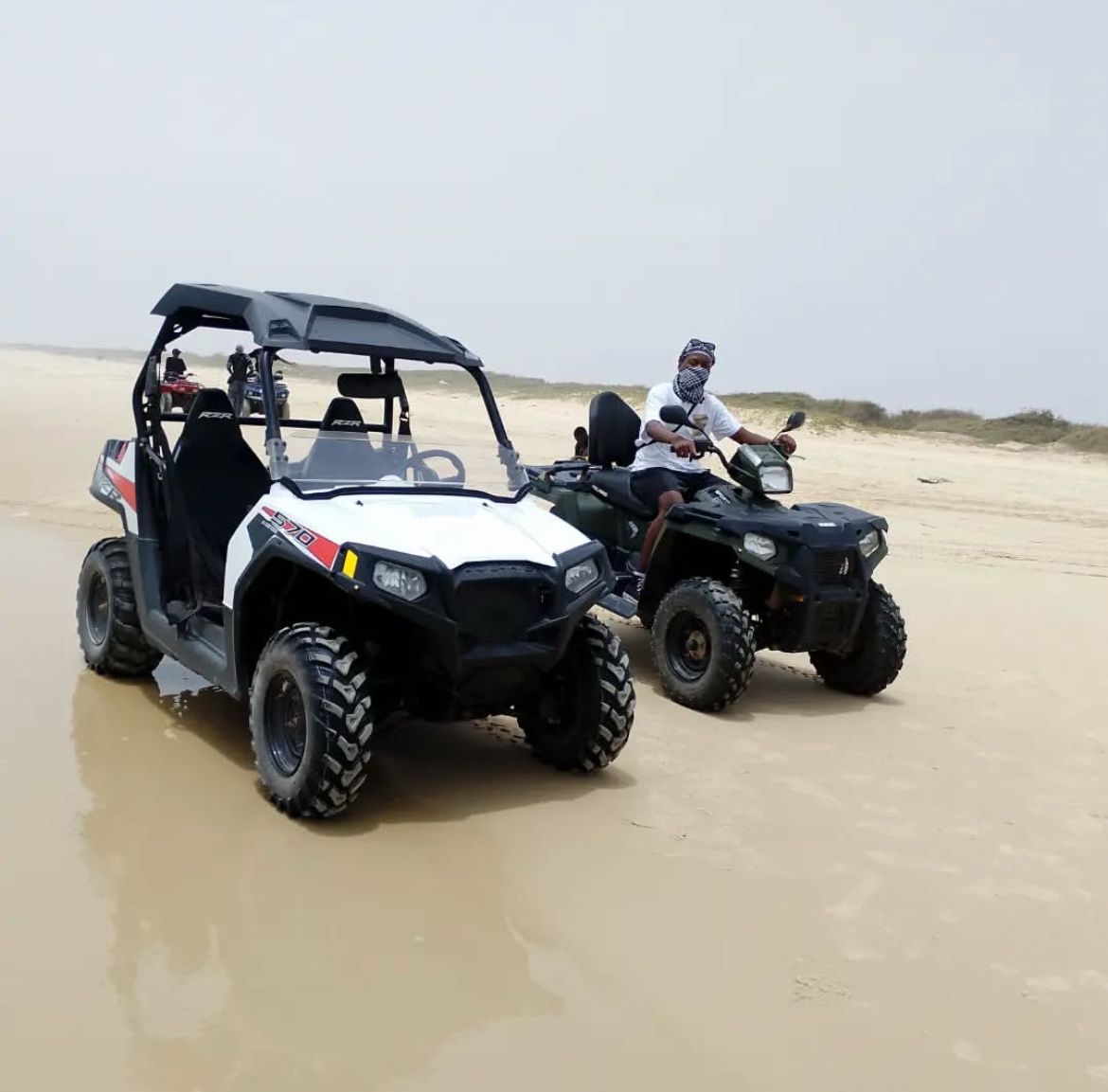 Buggy blanc et quad réunis sur une piste de sable au Lac Rose