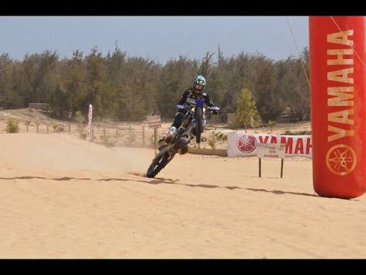 Pilote équipé en moto-cross pendant une session sur sable