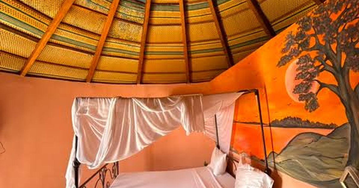 Chambre ventilée au toit traditionnel et lit sous moustiquaire au Lac Rose