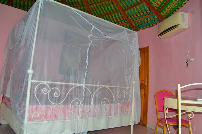 Chambre climatisée avec lit sous moustiquaire au Lac Rose